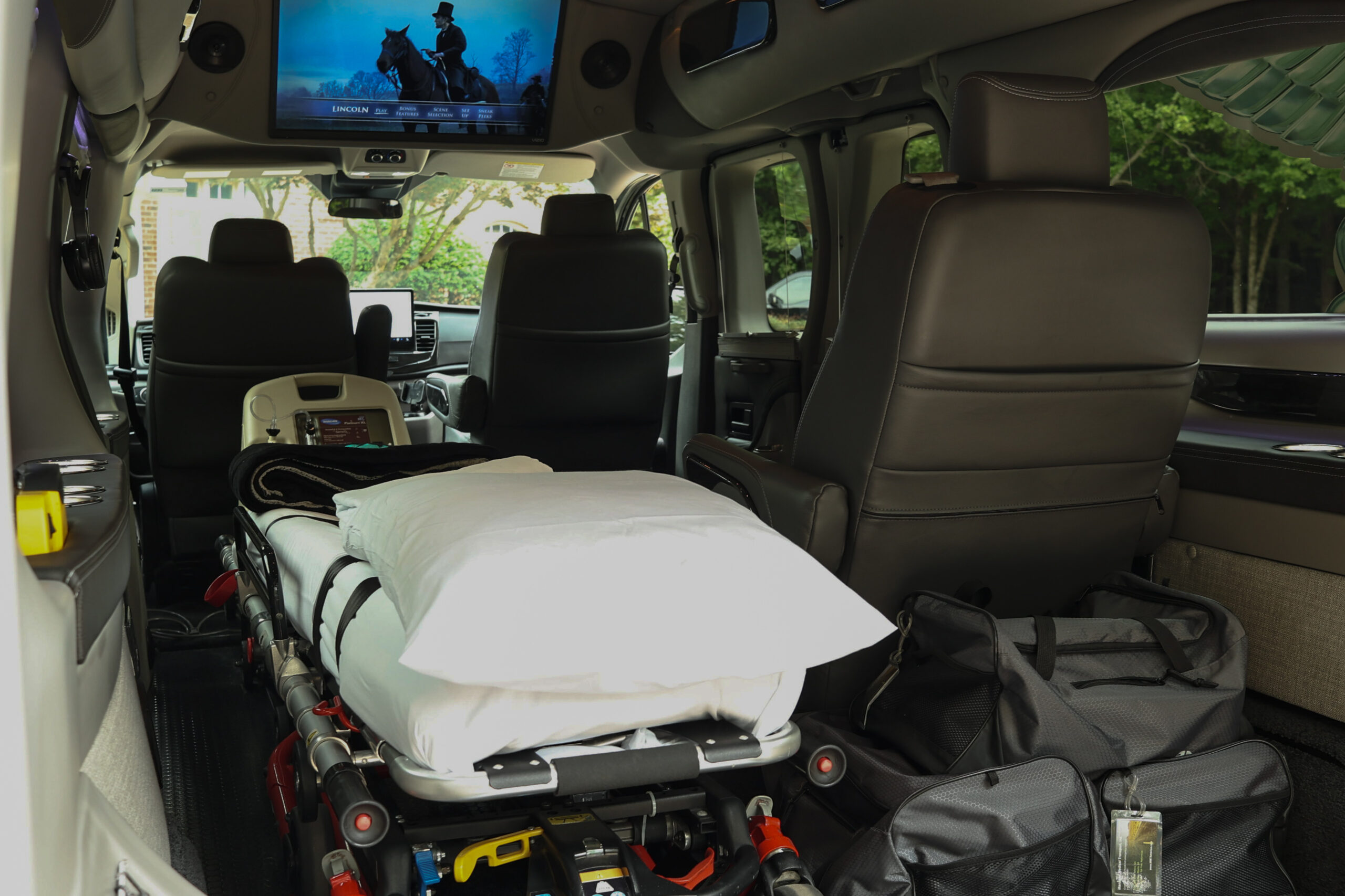 The image features a van equipped with safety features such as a car seat and head restraint, highlighting its suitability for long-distance medical transport. Managed Medical Transport, Inc. utilizes such vehicles to ensure safe and comfortable transportation for patients requiring medical assistance.