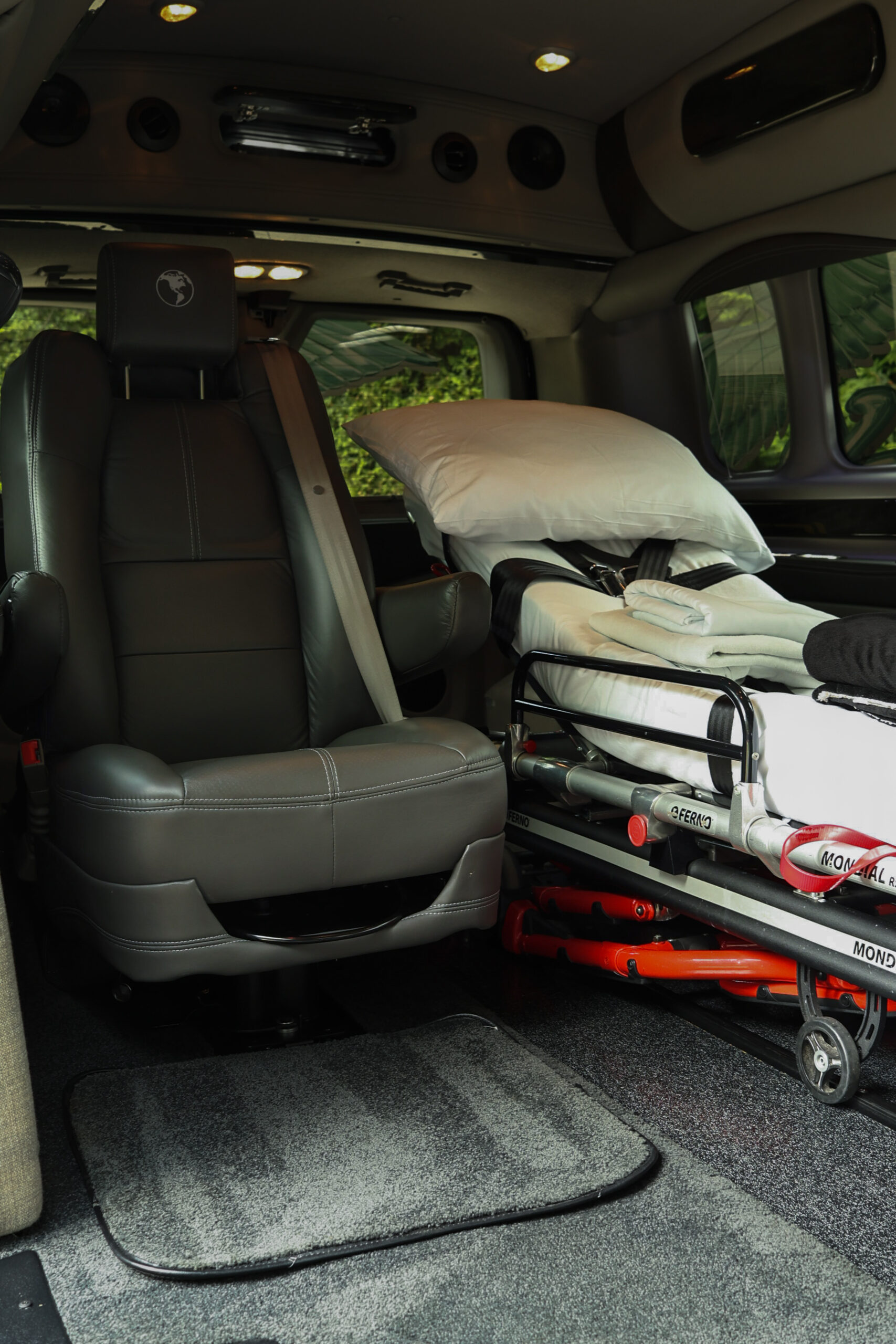 The interior of a minivan with seating and a stretcher visible.
